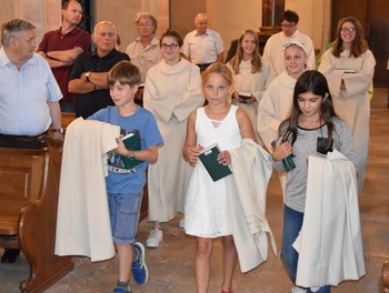 3 nouveaux servants portant leur aube lors de l'entrée de la messe