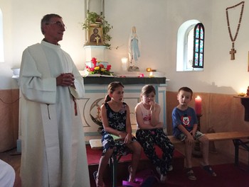 L'abbé Pierre Rebetez qui préside la messe avec les 3 enfants des fermes alentours