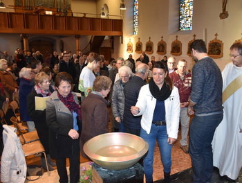 Chacun vient au fond baptismaux pour faire le signe de croix avec l'eau bénites