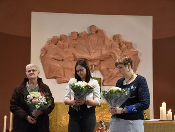 Le président de paroisse remet des fleurs aux trois sacristines pour les remercier du travail accompli tout au long de l'année